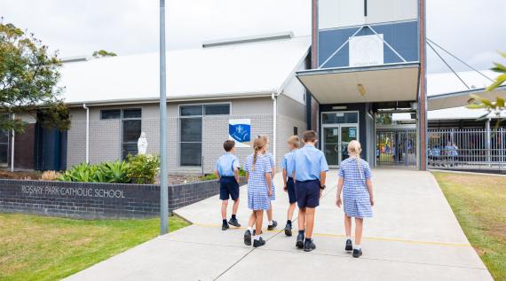 A group of children walking into their school.