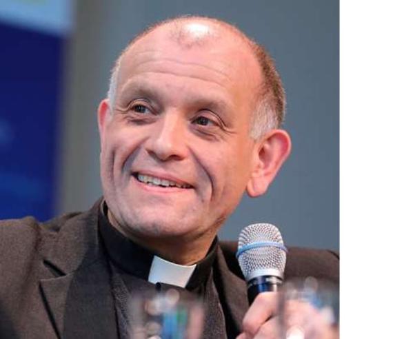 Fr Bechina holding microphone