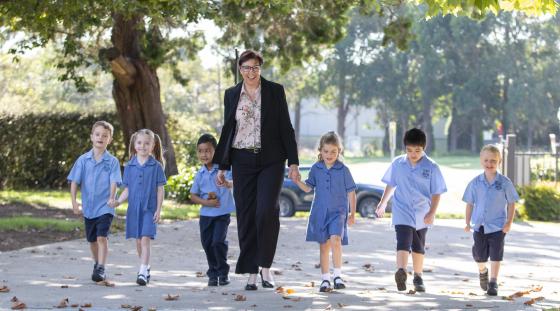 A teacher guiding a group of young students.
