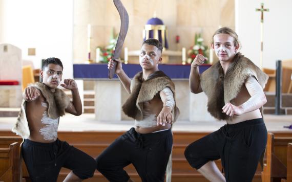 Three Aboriginal boys in traditional dress in the Catholic Church.