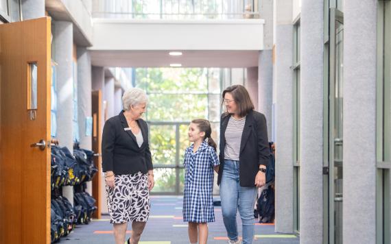A teacher showing a parent and child around the school.