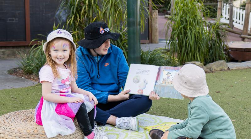 Preschooler reading in garden